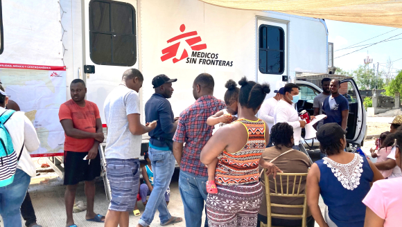 Migranten warten vor einer mobilen Klinik