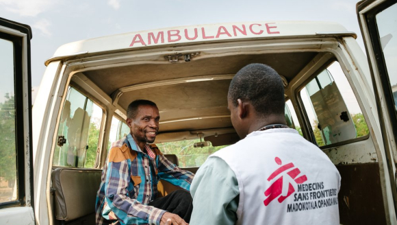 Ein Mitarbeiter hilft einem Patienten an Bord eines Krankenwagens