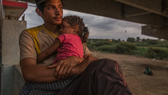 Flucht: junger Mann mit Tochter auf Arm