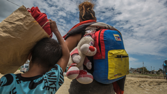 Eine Mutter und ihr Sohn auf der Flucht in Venezuela mit ihrem Gepäck