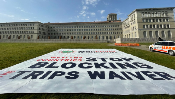 Das Gebäude der WTO und das Plakat zum TRIPS-Waiver