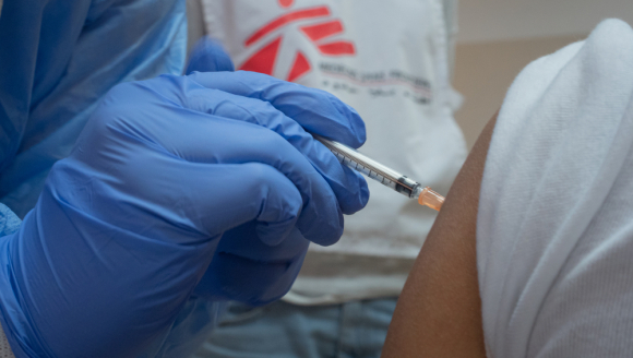 Nahaufnahme von einer Hand, die eine Covid-19 Impfung spritzt