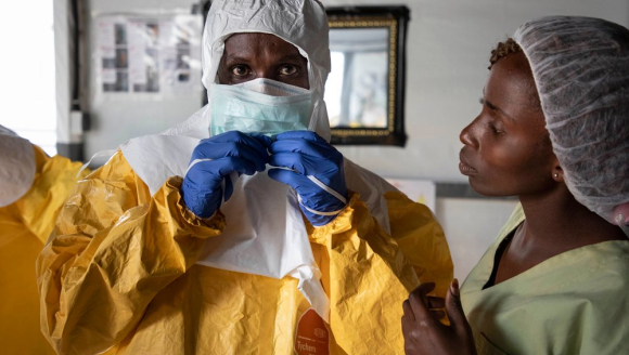Mitarbeiter in Schutzausrüstung vor Ebola-Transitzentrum
