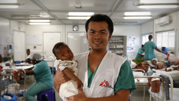 Krankenpfleger hält Baby auf dem Arm