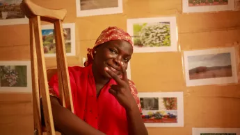 Frau mit Krücken zeigt Peace-Zeichen