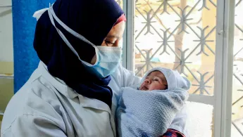 Eine Hebamme hält ein Baby