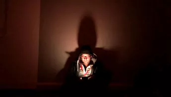 Oliver Barth schut in einem dunklen Luftschutzkeller auf sein Handy