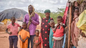 Der 50-jährige Borow Ali Khamis steht mit seiner Familie vor deren Unterkunft im Camp Dagahaley. Er war Landwirt und Viehzüchter in Somalia, hat aber aufgrund der langen Dürre alles verloren.