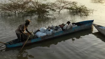 Ein Mann tritt in einem Kanu die Flucht vor der Flut an