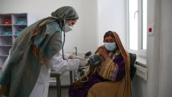 Die Krankenschwester Aziza Khushal überprüft Shahistos Vitalwerte im Sprechzimmer auf der Frauenseite des Krankenhauses von Ärzte ohne Grenzen in der Provinz Kandahar, Afghanistan.