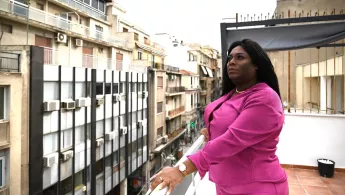 Yuli steht auf einem Balkon.