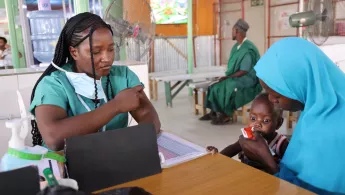 Eine unserer Mitarbeiter*innen versorgt ein Kind mit therapeutischer Fertignahrung. 