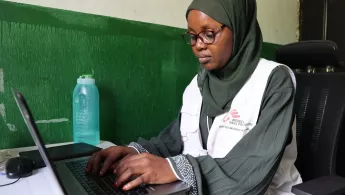 Frau sitzt und tippt am Computer