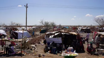 Ein Camp aus provisorischen Zeltunterkünften mit Menschen