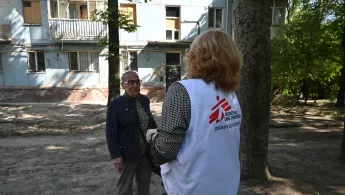 Eine unserer Mitarbeitenden spricht mit einer älteren Frau