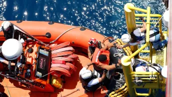 Eine gerettete Person klettert an Bord der Geo Barents