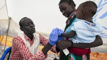 Eine Krankenschwester testet ein Kind auf Malaria.