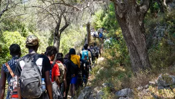 Ankommende laufen auf einem steinigen Weg auf Samos