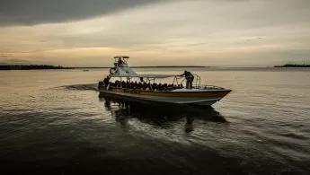 Menschen in einem Kahn auf einem breiten Fluss