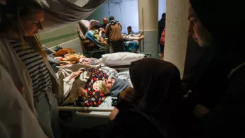 Behandelnde und Angehörige am Bett einer Patientin.