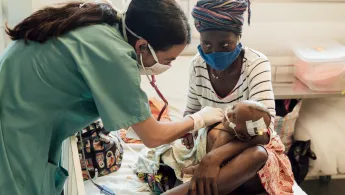 Ärztin Marianella Rodríguez untersucht eine sehr junge Patient*in auf der Intensivstation eines Krankenhauses in Sierra Leone. Ärztin untersucht Baby auf Intensivstation