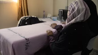 Frau wartet im Sprechzimmer