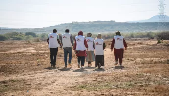 Sechs Mitarbeitende laufen über Sandstraße