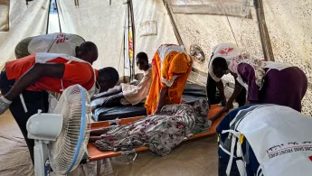 Mitarbeitende behandeln Kriegsverletzte auf Baren