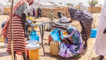 Frauen füllen Wasserkanister im Vertriebenencamp Alacha, Tschad Frauen füllen Wasserkanister im Vertriebenencamp Alacha, Tschad
