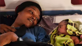 Mutter und Baby in Krankenbett darunter Titel der Publikation