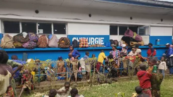 Schutzsuchende sitzen vor einem Krankenhaus, in Nord-Kivu  in der DR Kongo.