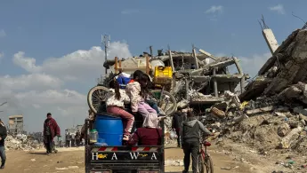 Gaza: Familie mit Hab und Gut inmitten zerstörter Gebäude