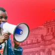 Mitarbeitender mit Megaphon vor rotem Hintergrund mit Bundestag