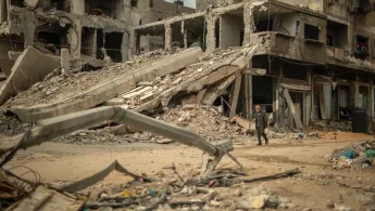 Ein Mann läuft durch eine zerstörte Nachbarschaft im Gazastreifen