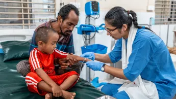 Ein kleiner Junge wird von einer Krankenschwester behandelt.
