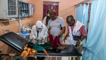 Im Notfallraum des Lehrkrankenhauses in al-Dschunaina. Kind lauf Behandlungsliege umgeben von Mitarbeitenden