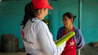 Mitarbeitende mit Clipboard spricht mit Patientin