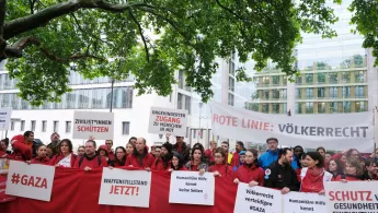 Menschen mit Plakaten demonstrieren vor Auswärtigem Amt