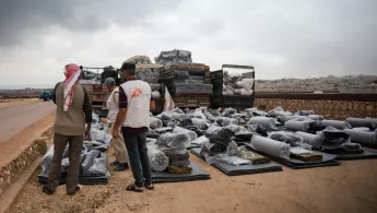 Mitarbeitende von uns sortieren Hilfsgüter und Matratzen.