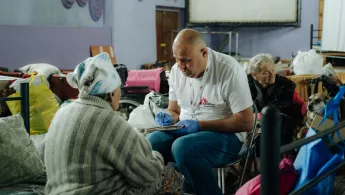 Ein Mitarbeiter von Ärzte ohne Grenzen spricht mit einer Patientin.