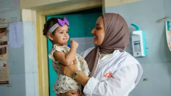 EIne Frau hat ein Kind auf dem Arm