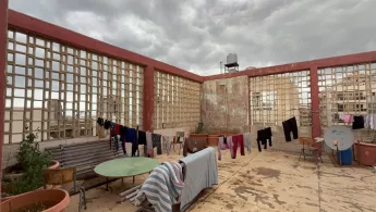 Wäsche hängt an Wäscheleinen auf einem Flachdach.