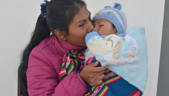 Die Gesundheitsförderin Maribel Camargo Paco küsst ihren 6 Monate alten Sohn