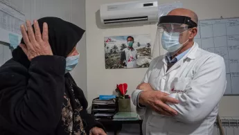 Eine Frau auf einer Krankenliege redet mit einem Arzt von Ärzte ohne Grenzen