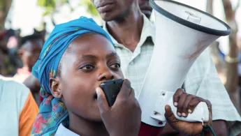 Frau mit Megaphone in der Demokratischen Republik Kongo