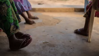 Beine und Füße von Menschen die im Kreis sitzen