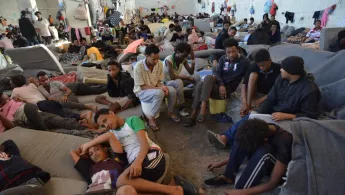 Geflüchtete und Migranten sitzen dicht gedrängt in einem Internierungslager 