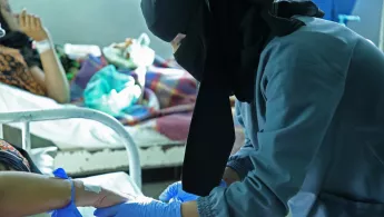 Eine Hebamme kümmert sich um eine Patientin