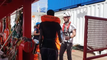 Einsatz im Mittelmeer: Ein Mitarbeiter hilft Geretteten an Bord der „Ocean Viking“. 