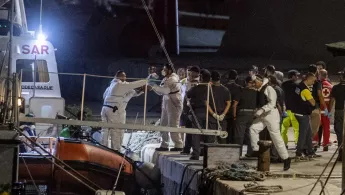 Ein einjähriges Kind wird von Mitarbeitern sicher von Bord der Ocean Viking an Land gebracht.